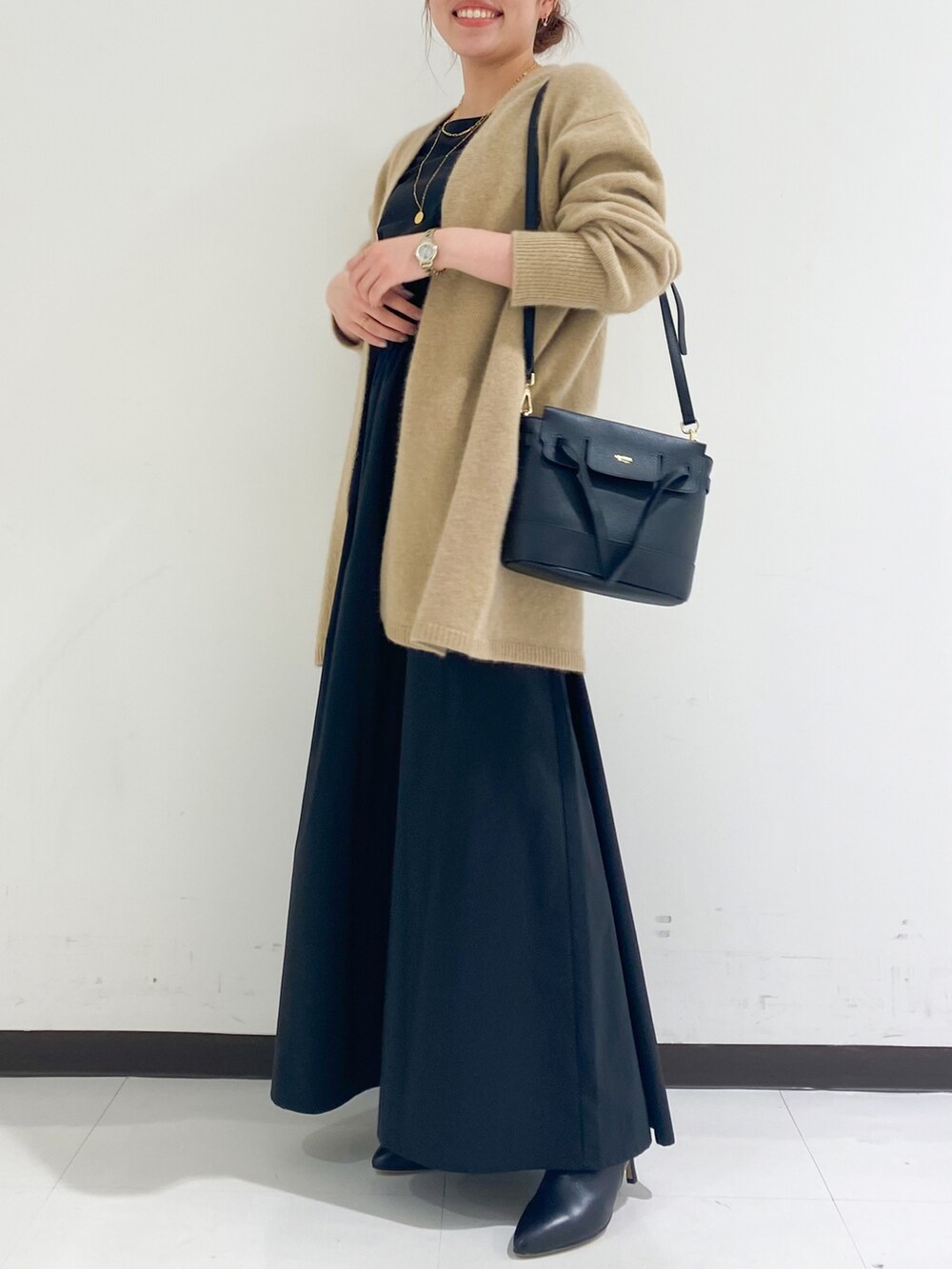 ベージュ系のカーディガン/ボレロ、ブラック系のワンピース/ドレス、ブラック系のブーツを着用したレディースの冬コーディネートの4枚目の写真