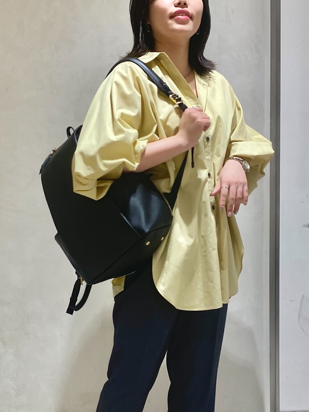 ベージュ系のシャツ/ブラウス、グレー系のスラックス、ブラック系のバックパック/リュックを着用したレディースの秋コーディネートの2枚目の写真