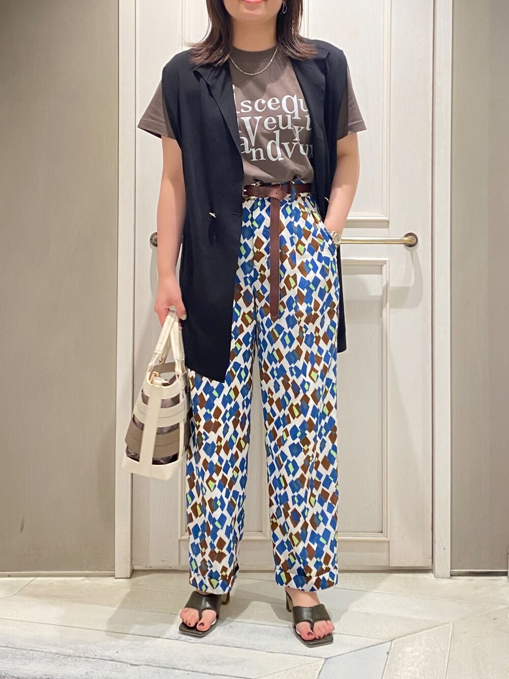 ブラック系のニット/セーター、グリーン系のサンダル、その他のその他パンツを着用したレディースの春コーディネートの2枚目の写真