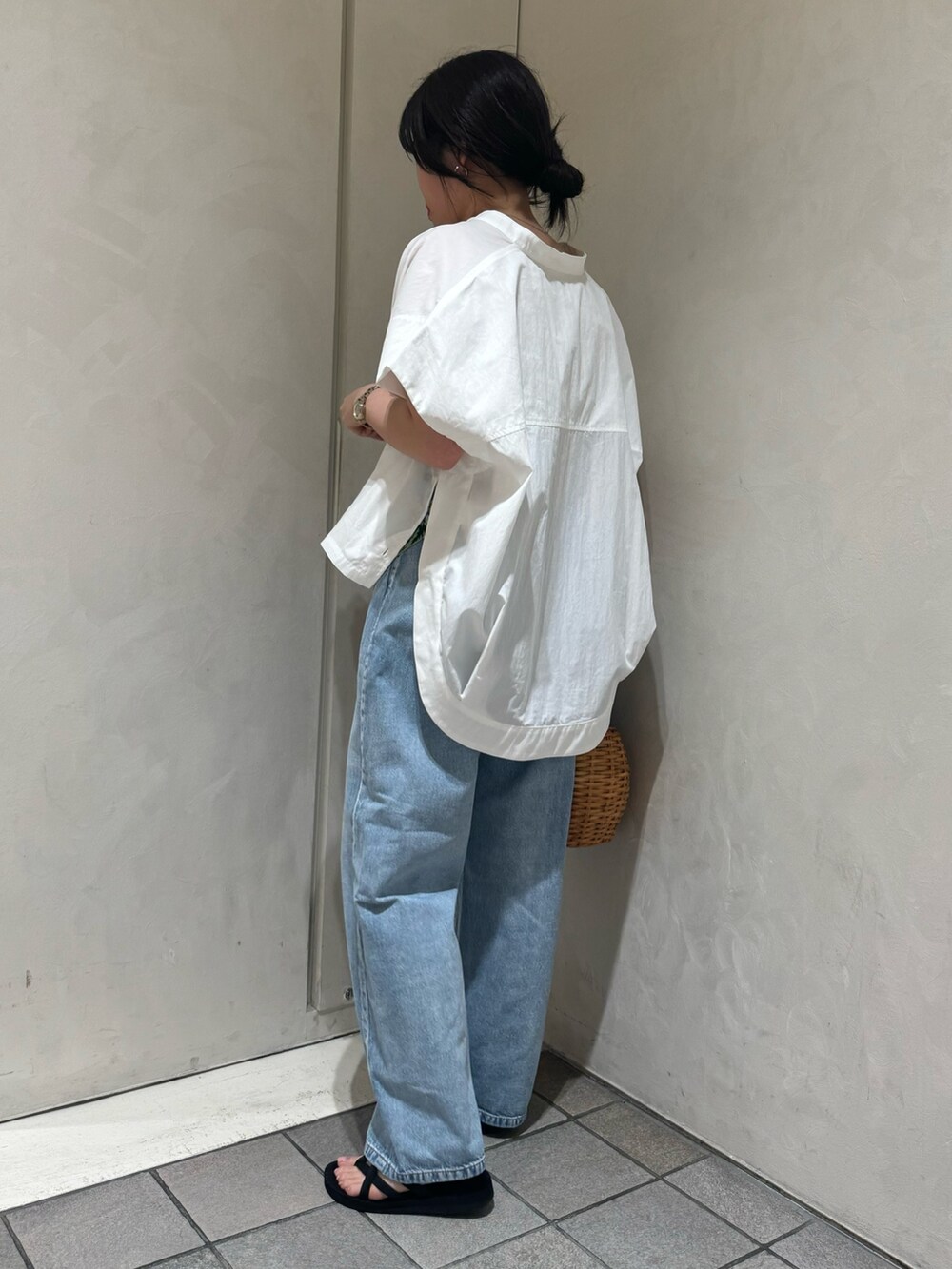 ブラック系のトートバッグ、ブルー系のデニムパンツ、ホワイト系のシャツ/ブラウスを着用したレディースの夏コーディネートの8枚目の写真