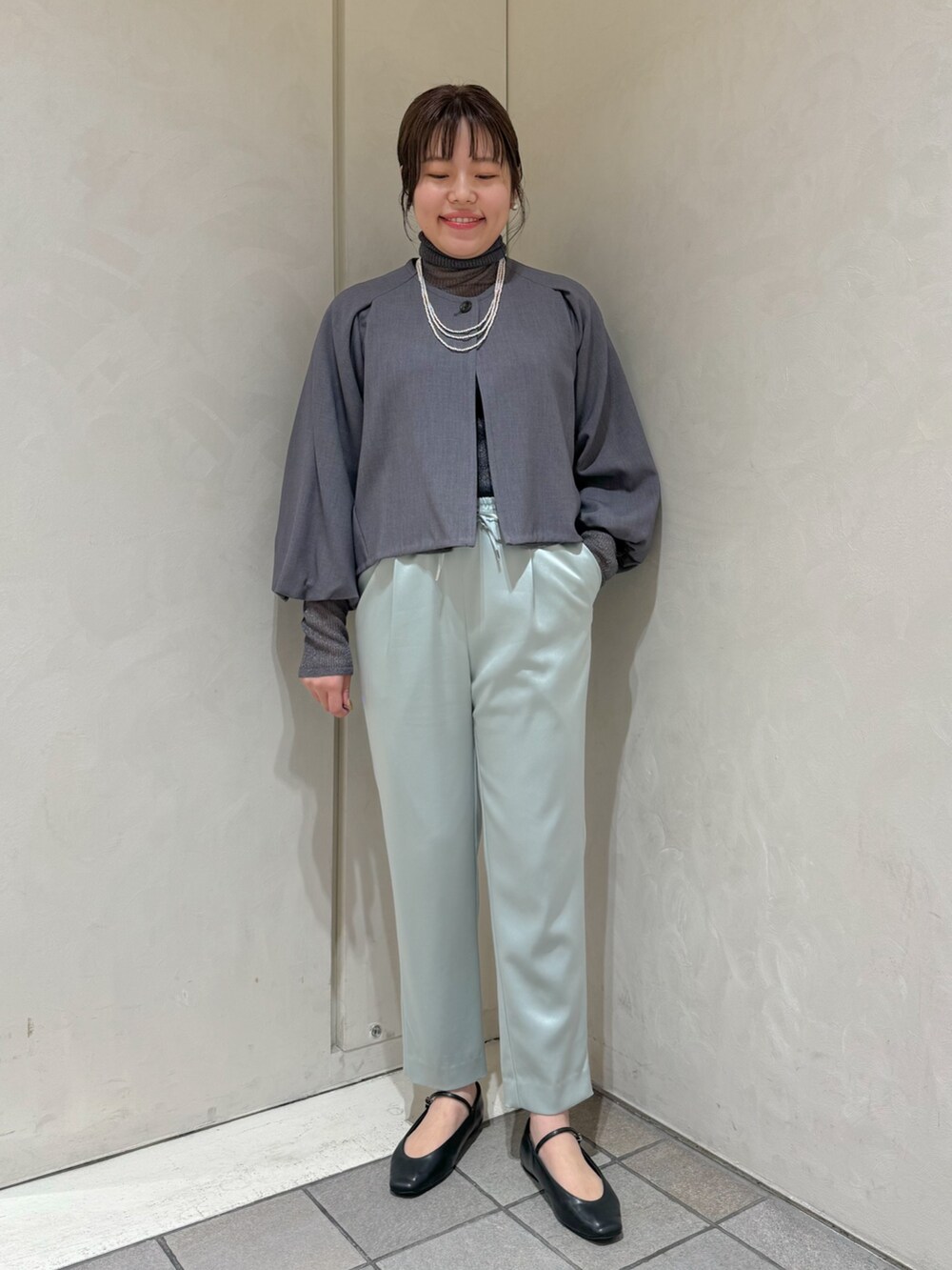 グリーン系のスラックス、グレー系のニット/セーター、グレー系のテーラードジャケットを着用したレディースの秋コーディネートの3枚目の写真
