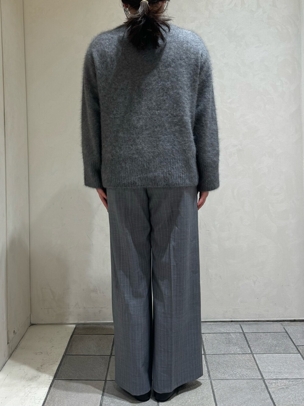 グレー系のニット/セーター、その他のスラックス、ブラック系のボストンバッグを着用したレディースの秋コーディネートの8枚目の写真