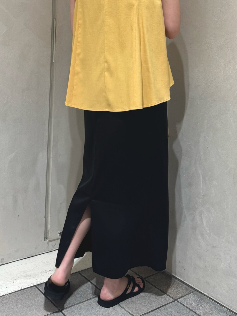イエロー系のシャツ/ブラウス、ブラック系のスカートを着用したレディースの夏コーディネートの6枚目の写真