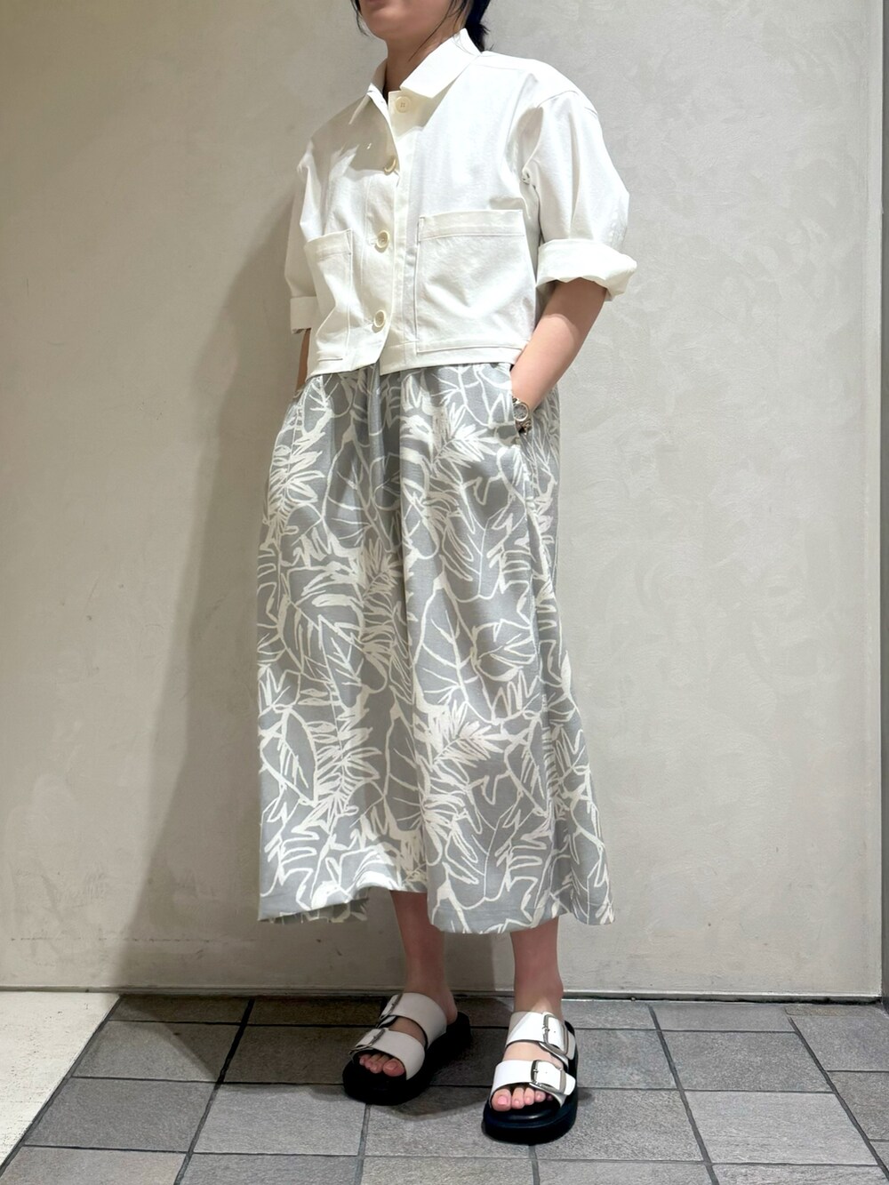 ホワイト系のブルゾン、グレー系のワンピースを着用したレディースの夏コーディネートの4枚目の写真