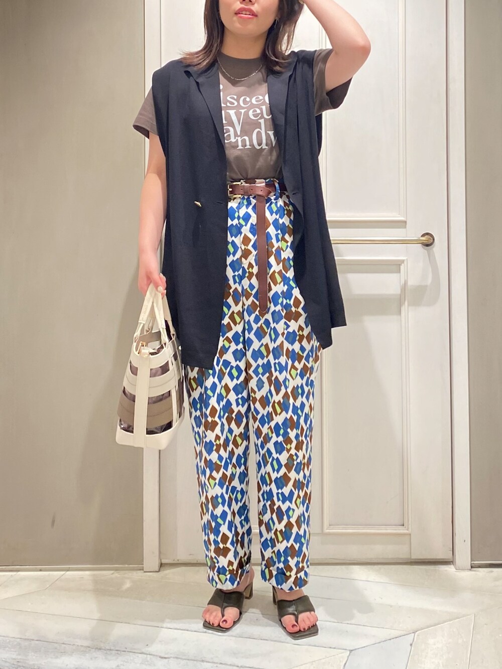 ブラック系のニット/セーター、グリーン系のサンダル、その他のその他パンツを着用したレディースの春コーディネートの3枚目の写真