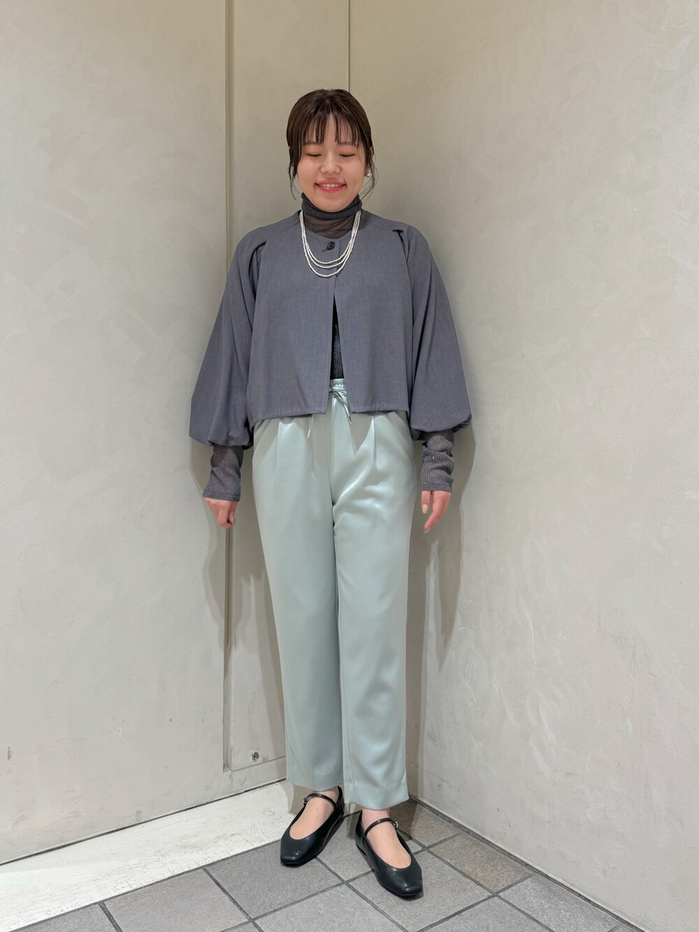 グリーン系のスラックス、グレー系のニット/セーター、グレー系のテーラードジャケットを着用したレディースの秋コーディネートの4枚目の写真