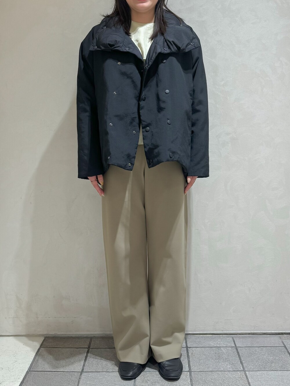 ブラック系のダウンジャケット/コート、グリーン系のスラックスを着用したレディースの秋コーディネートの5枚目の写真