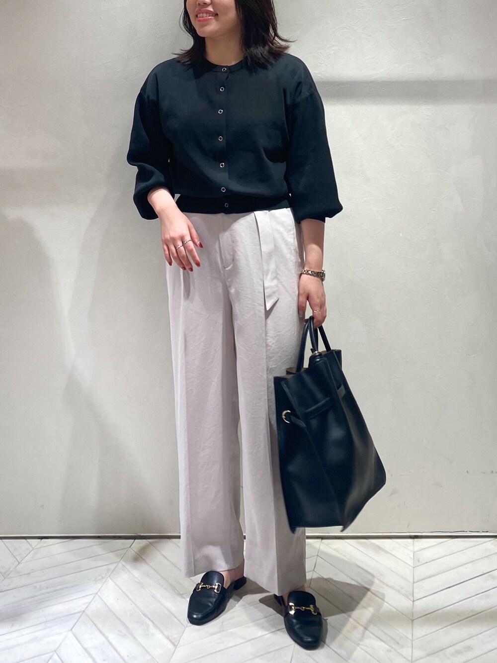 ブラック系のカーディガン/ボレロ、ピンク系のスラックス、ブラック系のトートバッグを着用したレディースの秋コーディネートの6枚目の写真