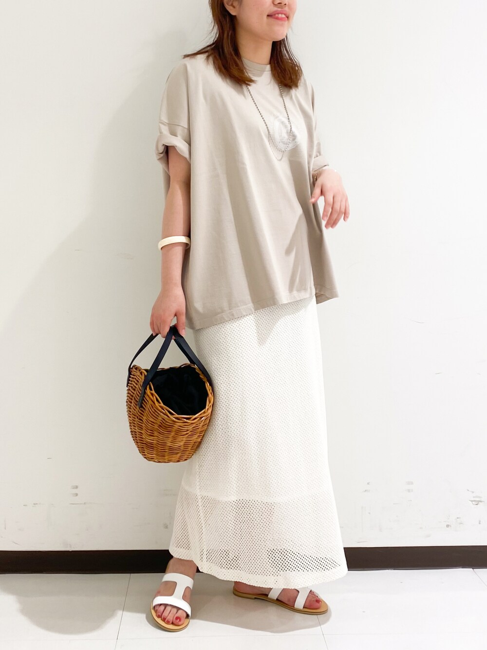 ベージュ系のTシャツ/カットソー、ホワイト系のスカート、ホワイト系のパンプスを着用したレディースの春コーディネートの3枚目の写真