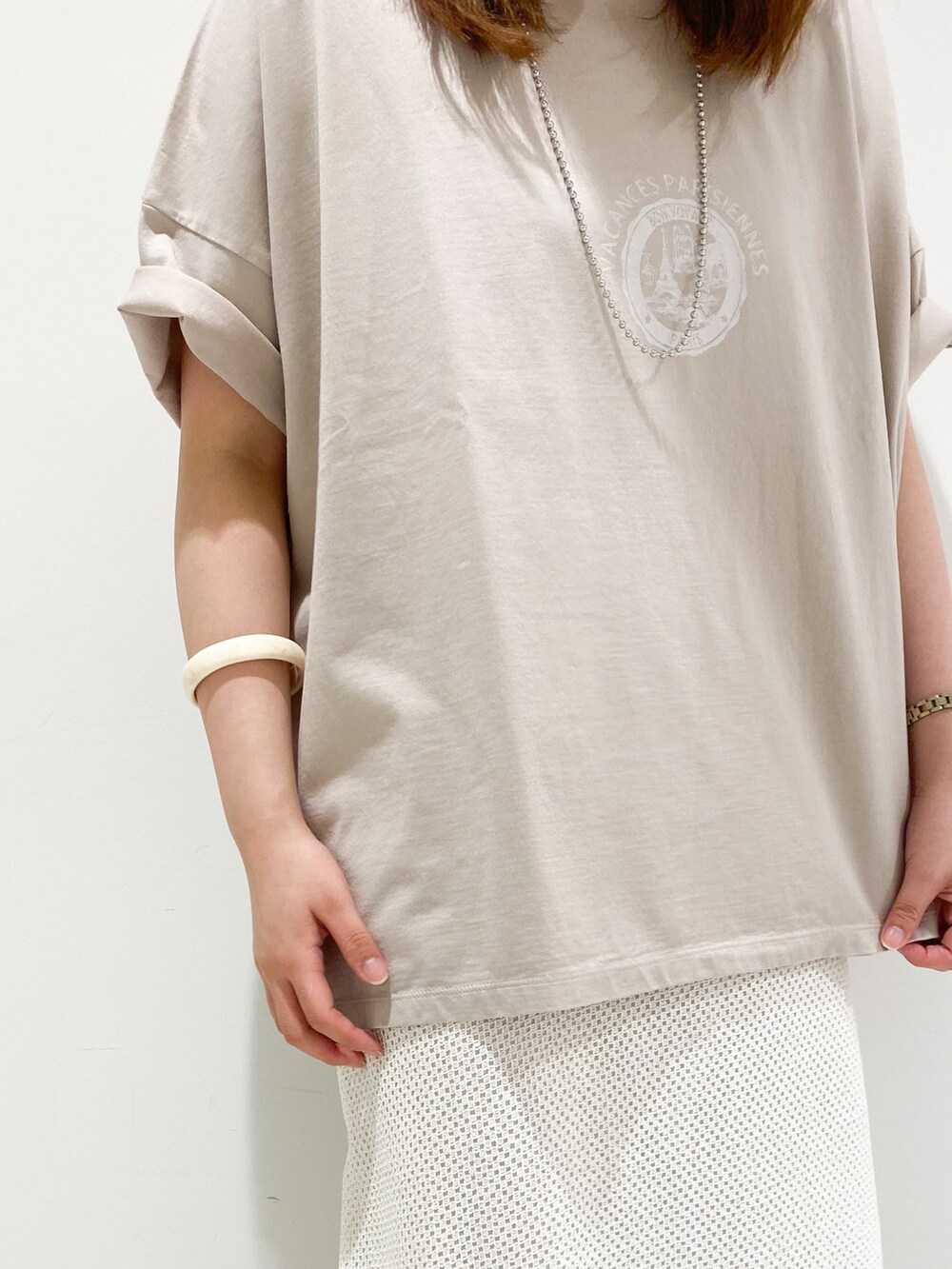 ベージュ系のTシャツ/カットソー、ホワイト系のスカート、ホワイト系のパンプスを着用したレディースの春コーディネートの4枚目の写真