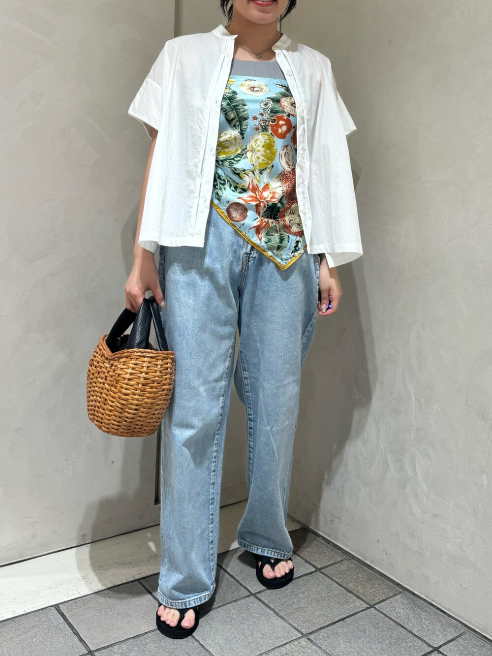 ブラック系のトートバッグ、ブルー系のデニムパンツ、ホワイト系のシャツ/ブラウスを着用したレディースの夏コーディネートの3枚目の写真