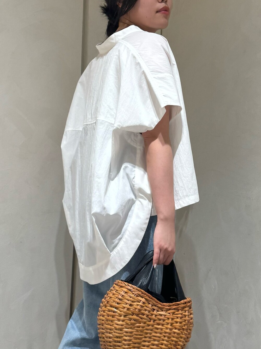 ブラック系のトートバッグ、ブルー系のデニムパンツ、ホワイト系のシャツ/ブラウスを着用したレディースの夏コーディネートの6枚目の写真