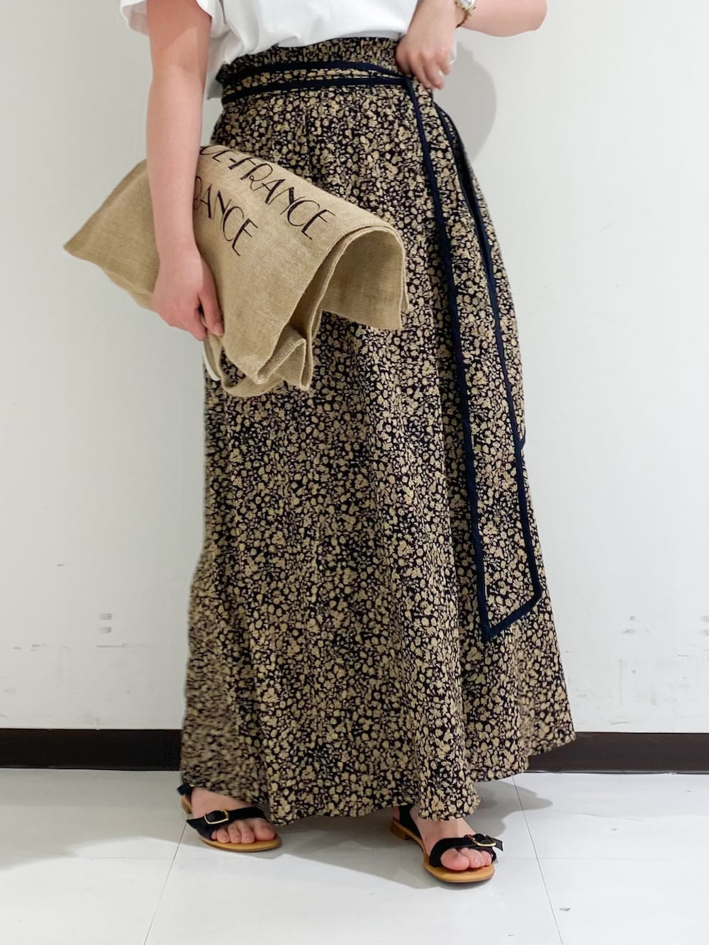 ブラウン系のTシャツ/カットソー、ブラック系のトートバッグ、ブラック系のスカートを着用したレディースの春コーディネートの4枚目の写真