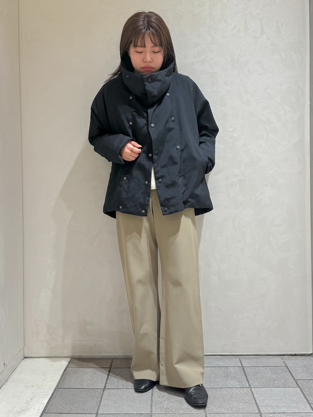 ブラック系のダウンジャケット/コート、グリーン系のスラックスを着用したレディースの秋コーディネートの2枚目の写真