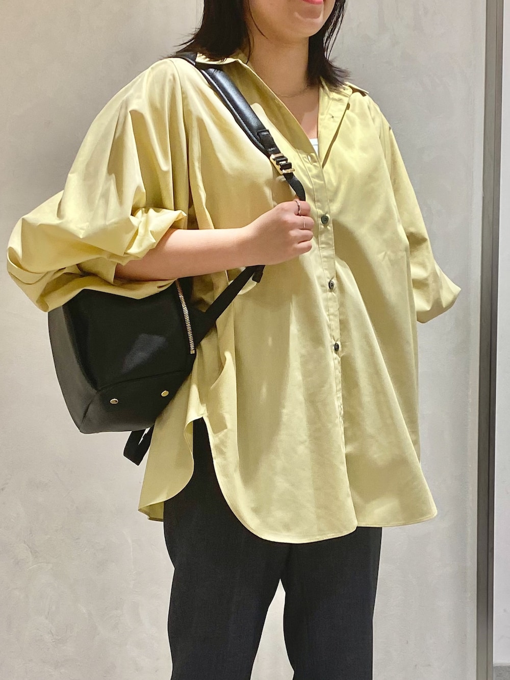 ベージュ系のシャツ/ブラウス、グレー系のスラックス、ブラック系のバックパック/リュックを着用したレディースの秋コーディネートの3枚目の写真