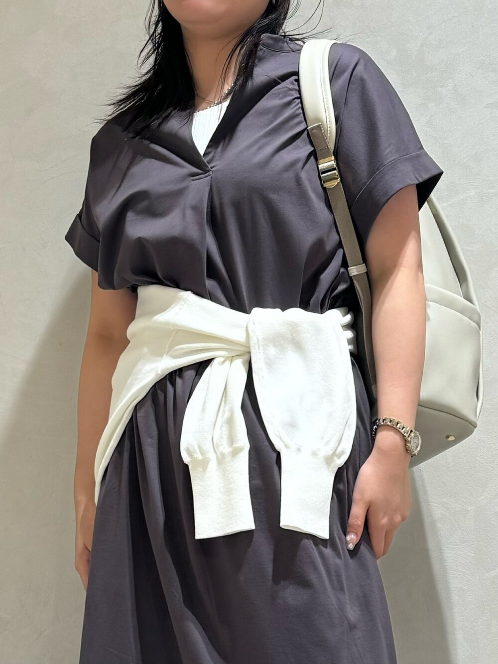 グレー系のワンピース、ブラック系のバックパック/リュック、ホワイト系のカーディガン/ボレロを着用したレディースの夏コーディネートの5枚目の写真