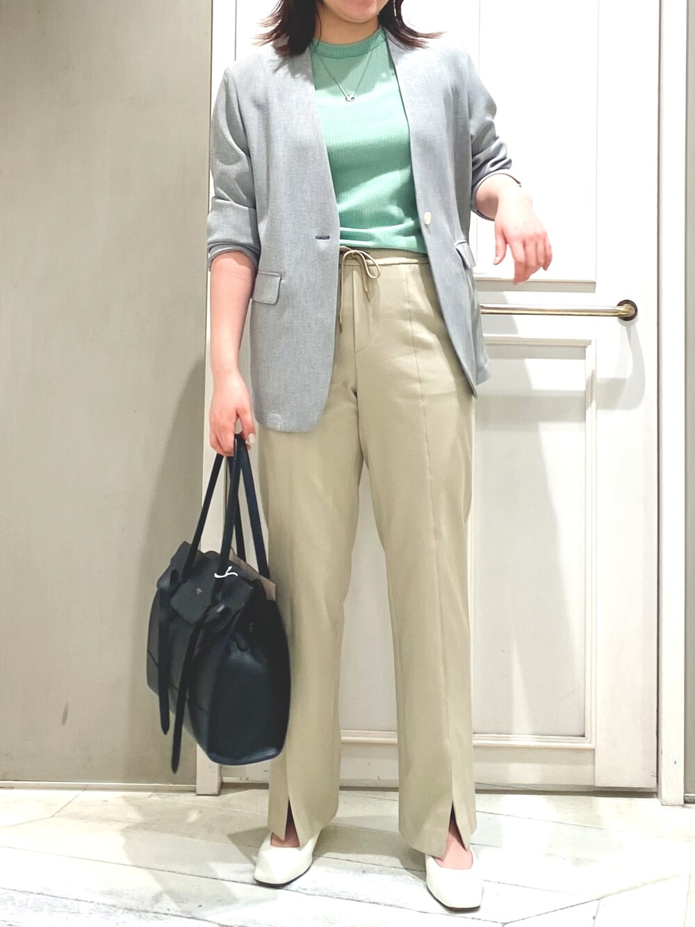 グリーン系のTシャツ/カットソー、ベージュ系のその他パンツ、ブラック系のノーカラージャケットを着用したレディースの春コーディネートの3枚目の写真