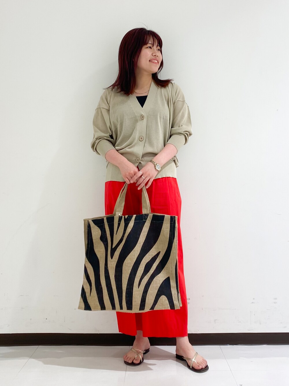 ベージュ系のカーディガン/ボレロ、レッド系のその他パンツ、ブラック系のトートバッグを着用したレディースの夏コーディネートの5枚目の写真