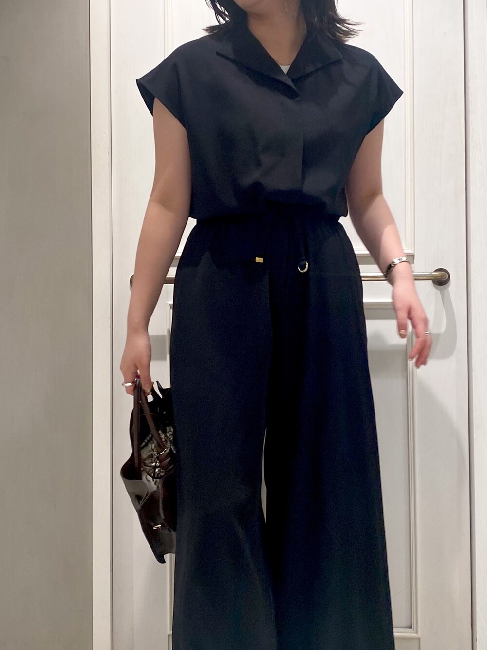 ブラック系のつなぎ/オールインワン、ブラウン系のショルダーバッグ、ホワイト系のサンダルを着用したレディースの夏コーディネートの3枚目の写真