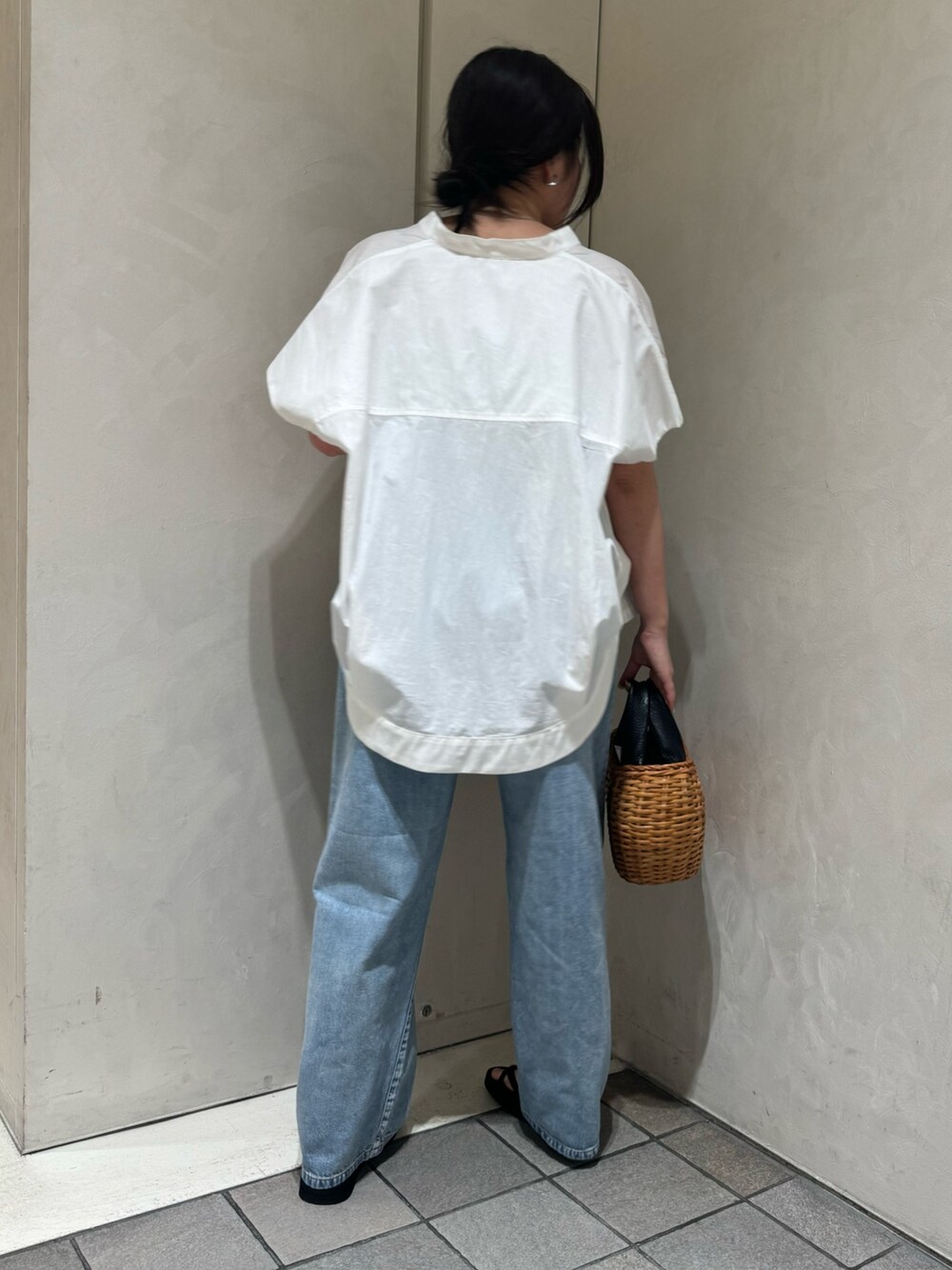 ブラック系のトートバッグ、ブルー系のデニムパンツ、ホワイト系のシャツ/ブラウスを着用したレディースの夏コーディネートの7枚目の写真