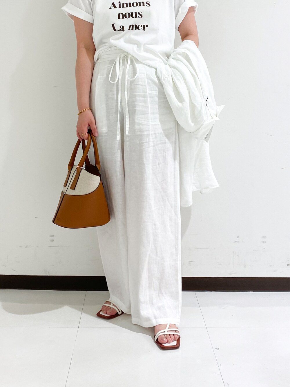 ブラウン系のTシャツ/カットソー、イエロー系のショルダーバッグ、ホワイト系のその他パンツを着用したレディースの夏コーディネートの5枚目の写真