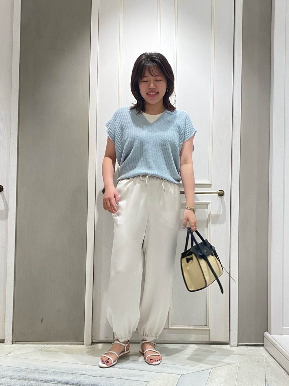 ブルー系のニット/セーター、ホワイト系のその他パンツ、ホワイト系のサンダルを着用したレディースの夏コーディネートの2枚目の写真