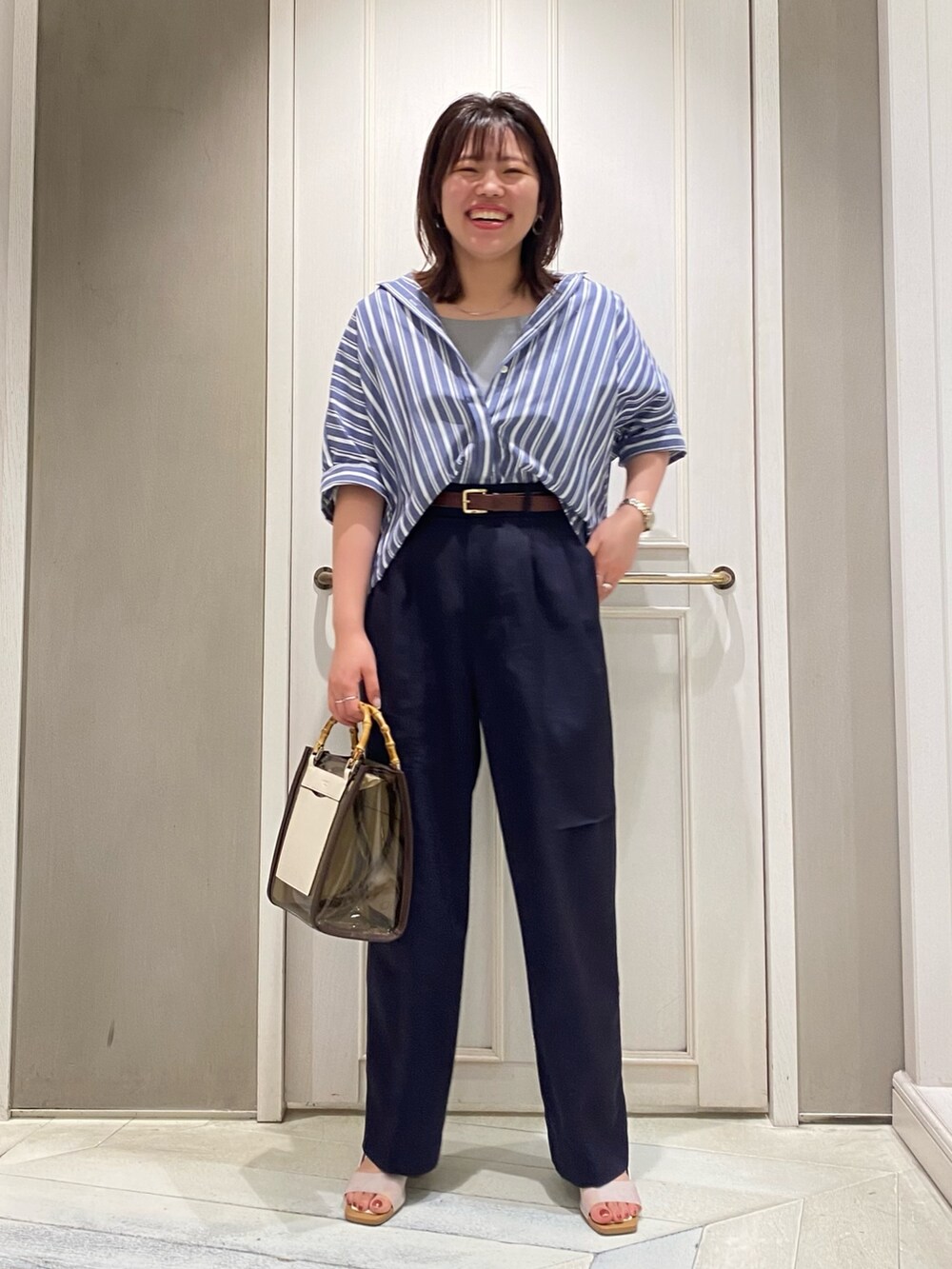 ブラウン系のトートバッグ、ホワイト系のサンダル、ブルー系のその他パンツを着用したレディースの夏コーディネートの6枚目の写真