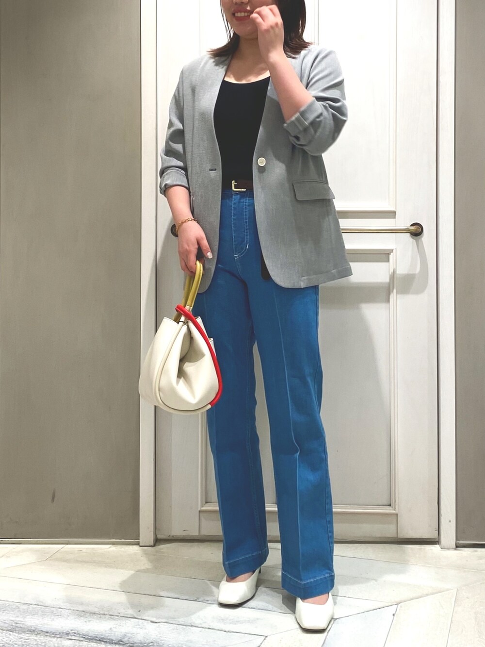 ブラック系のタンクトップ、ブルー系のデニムパンツ、ブラック系のノーカラージャケットを着用したレディースの春コーディネートの4枚目の写真