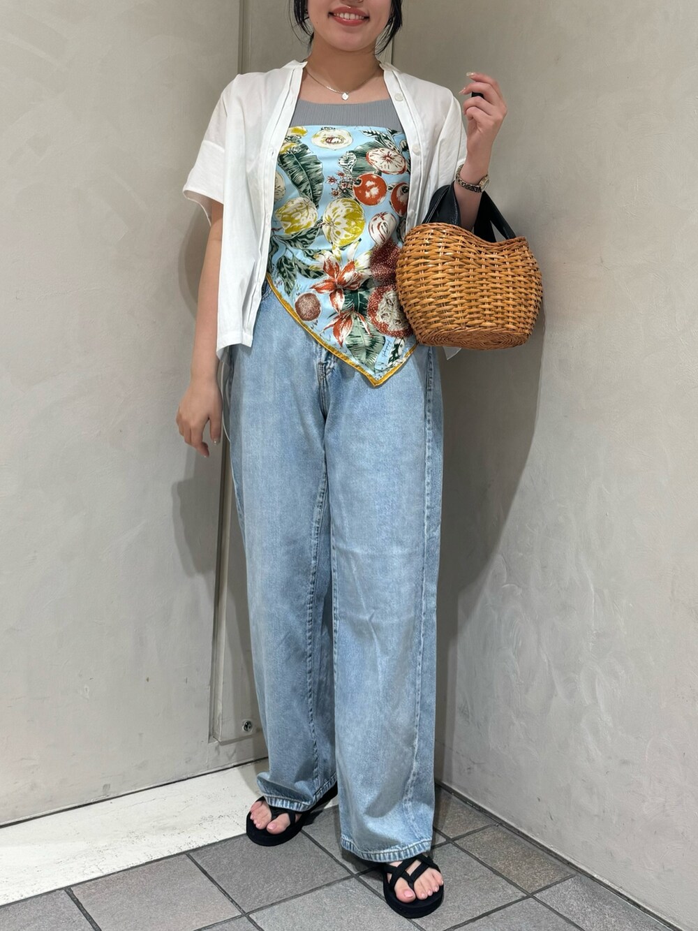 ブラック系のトートバッグ、ブルー系のデニムパンツ、ホワイト系のシャツ/ブラウスを着用したレディースの夏コーディネートの4枚目の写真