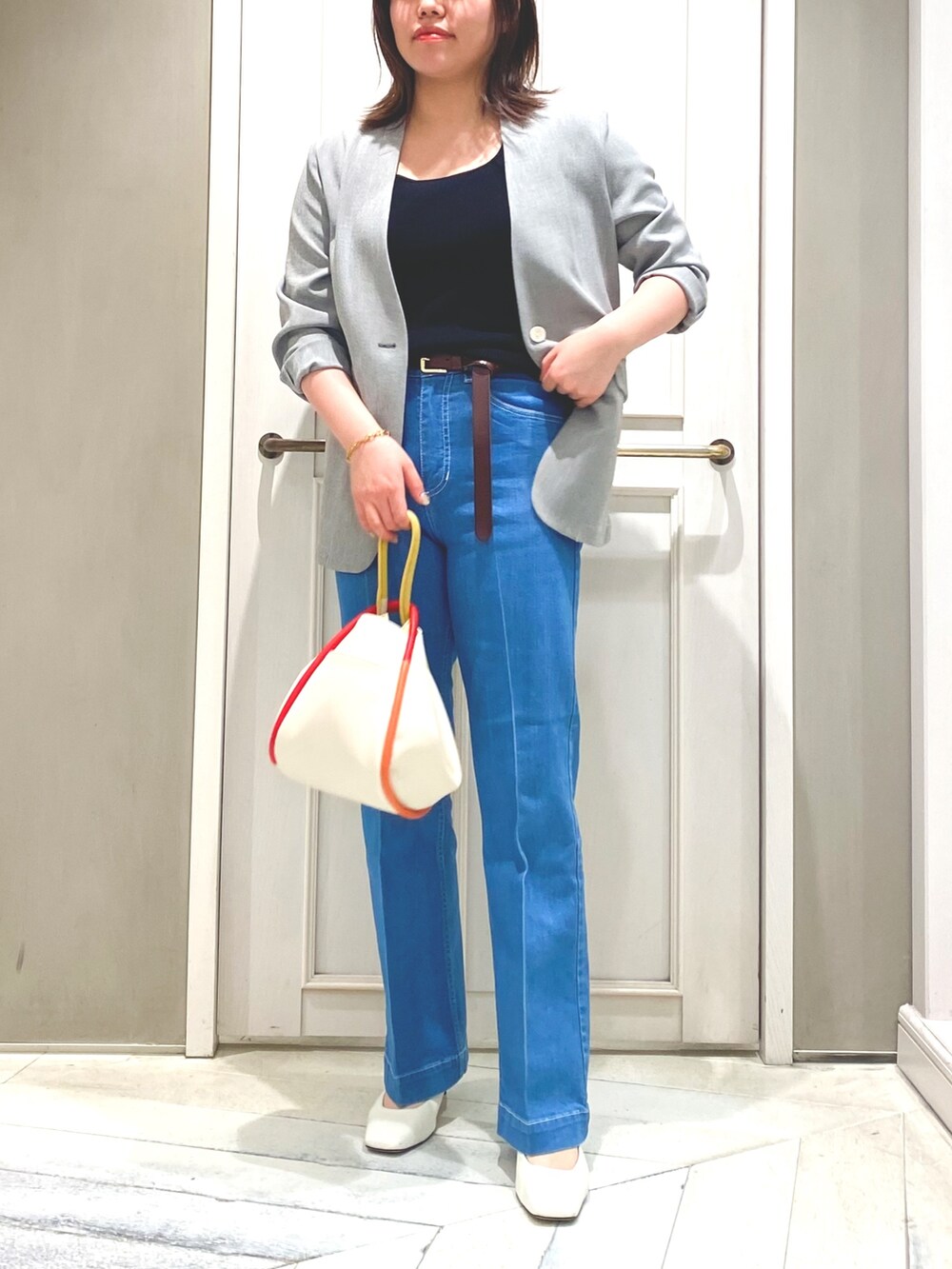 ブラック系のタンクトップ、ブルー系のデニムパンツ、ブラック系のノーカラージャケットを着用したレディースの春コーディネートの3枚目の写真