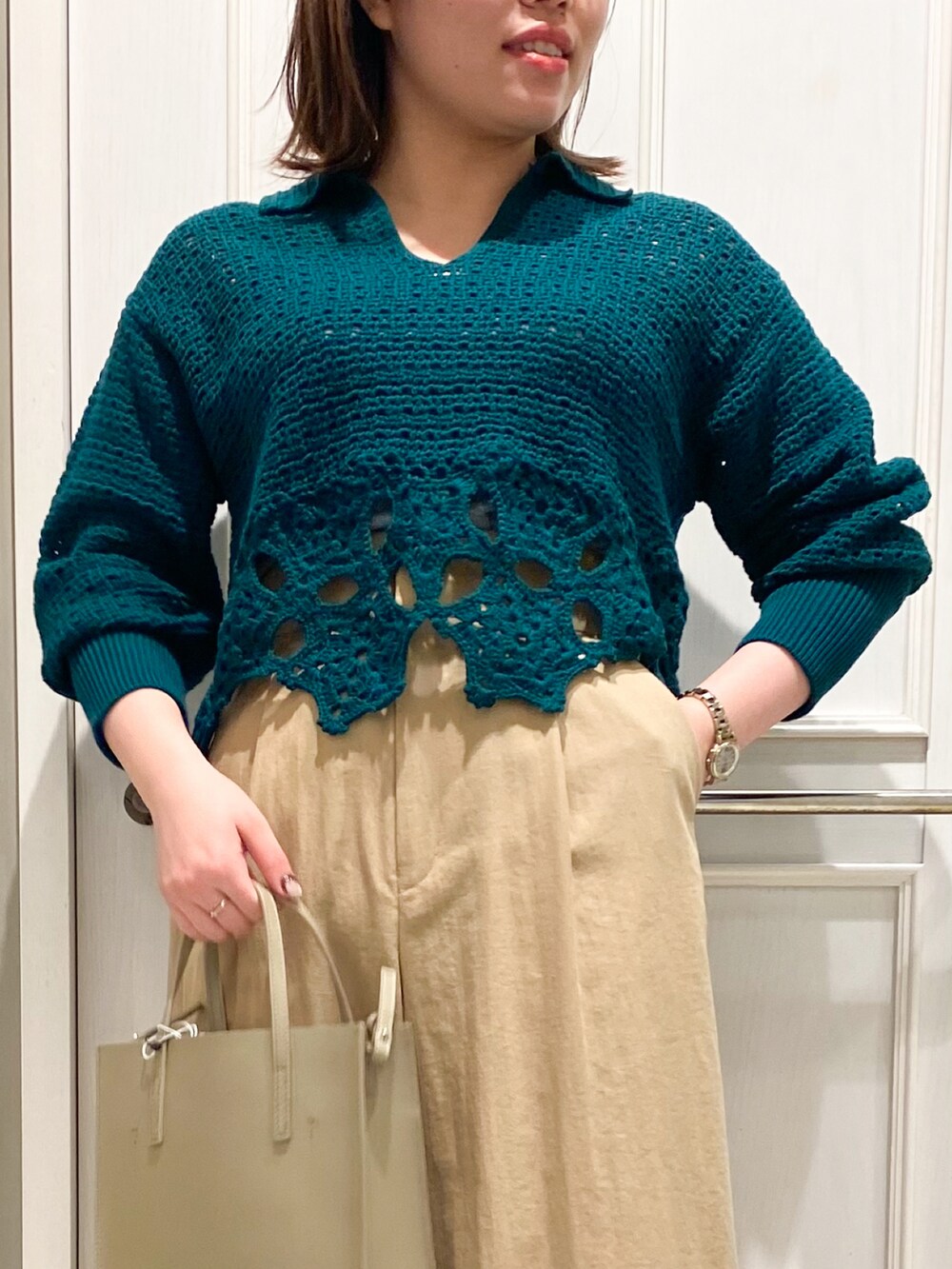 ベージュ系のトートバッグ、ベージュ系のその他パンツ、グリーン系のニット/セーターを着用したレディースの冬コーディネートの4枚目の写真