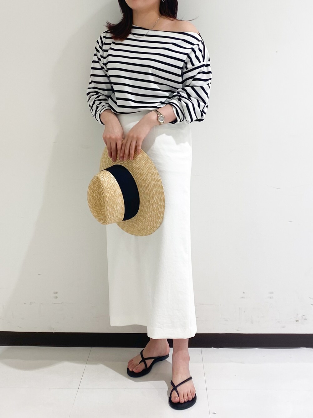 ブルー系のTシャツ/カットソー、ホワイト系のスカート、ブラック系のサンダルを着用したレディースの夏コーディネートの2枚目の写真