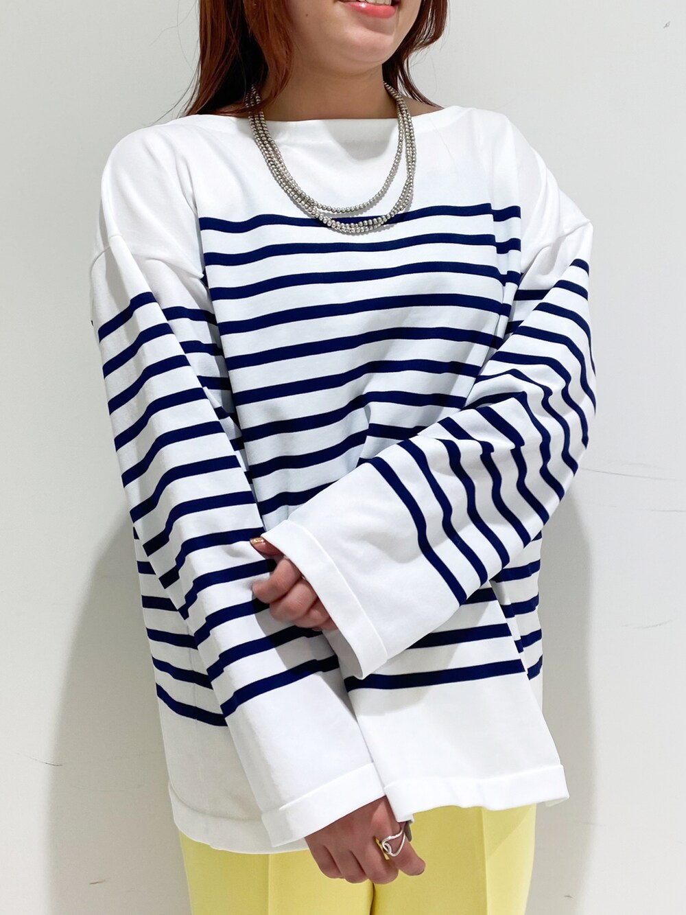 ブルー系のニット/セーター、ホワイト系のショルダーバッグ、ブラック系のパンプスを着用したレディースの冬コーディネートの5枚目の写真