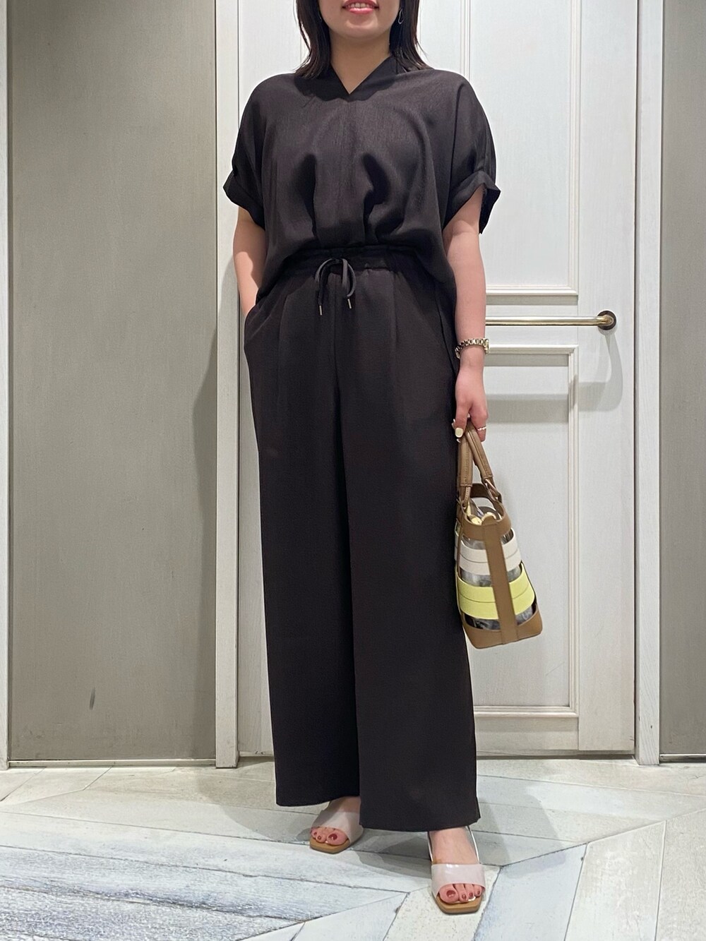 ブラウン系のシャツ/ブラウス、イエロー系のハンドバッグ、ホワイト系のサンダルを着用したレディースの夏コーディネートの3枚目の写真