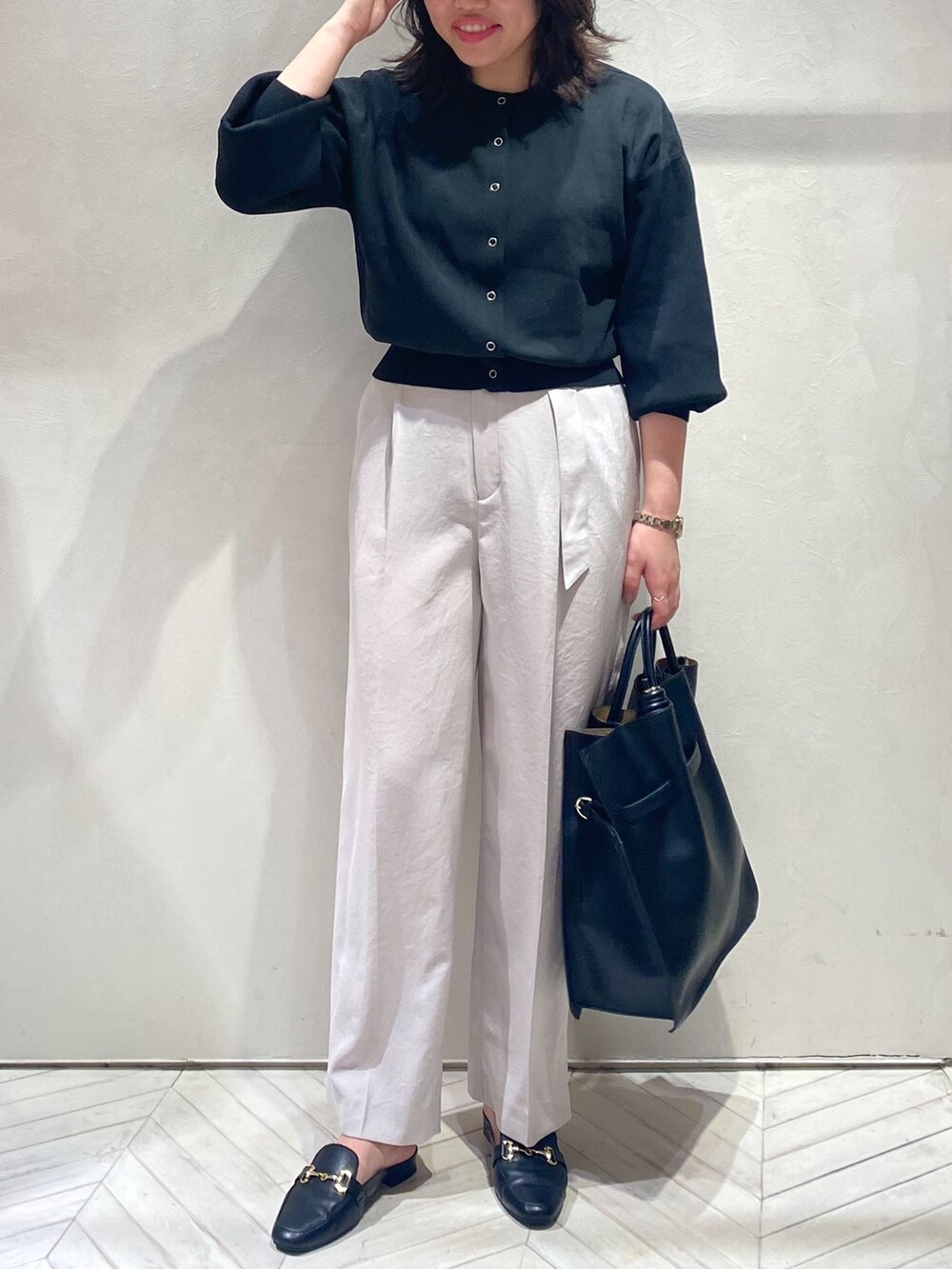 ブラック系のカーディガン/ボレロ、ピンク系のスラックス、ブラック系のトートバッグを着用したレディースの秋コーディネートの3枚目の写真