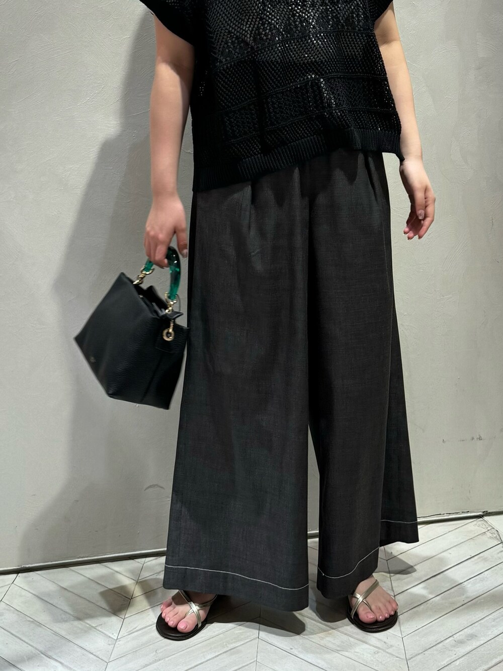 ブラック系のニット/セーター、ブラック系のデニムパンツを着用したレディースの春コーディネートの4枚目の写真