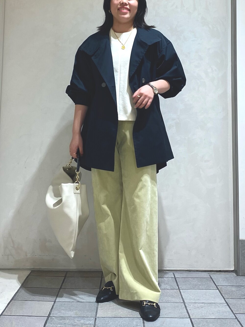 ホワイト系のTシャツ/カットソー、ブルー系のトレンチコート、グリーン系のその他パンツを着用したレディースの秋コーディネートの3枚目の写真