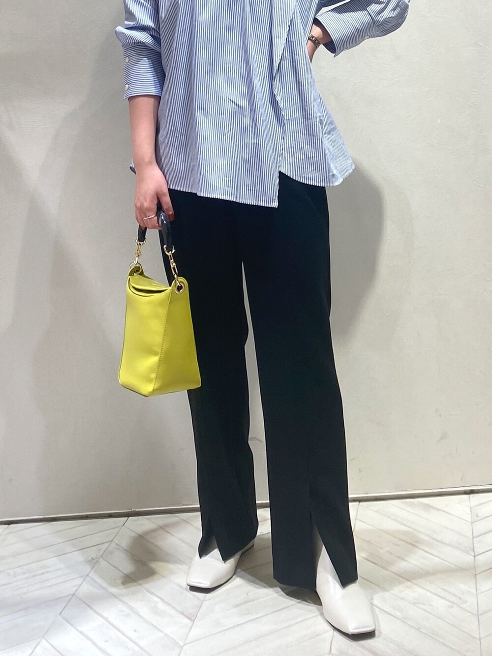 ブルー系のシャツ/ブラウス、ブルー系のハンドバッグ、ブラック系のスラックスを着用したレディースの秋コーディネートの2枚目の写真