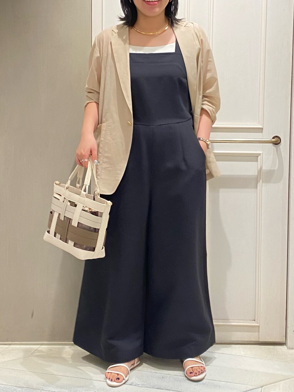 ブラック系のつなぎ/オールインワン、ベージュ系のテーラードジャケット、ベージュ系のハンドバッグを着用したレディースの夏コーディネートの4枚目の写真
