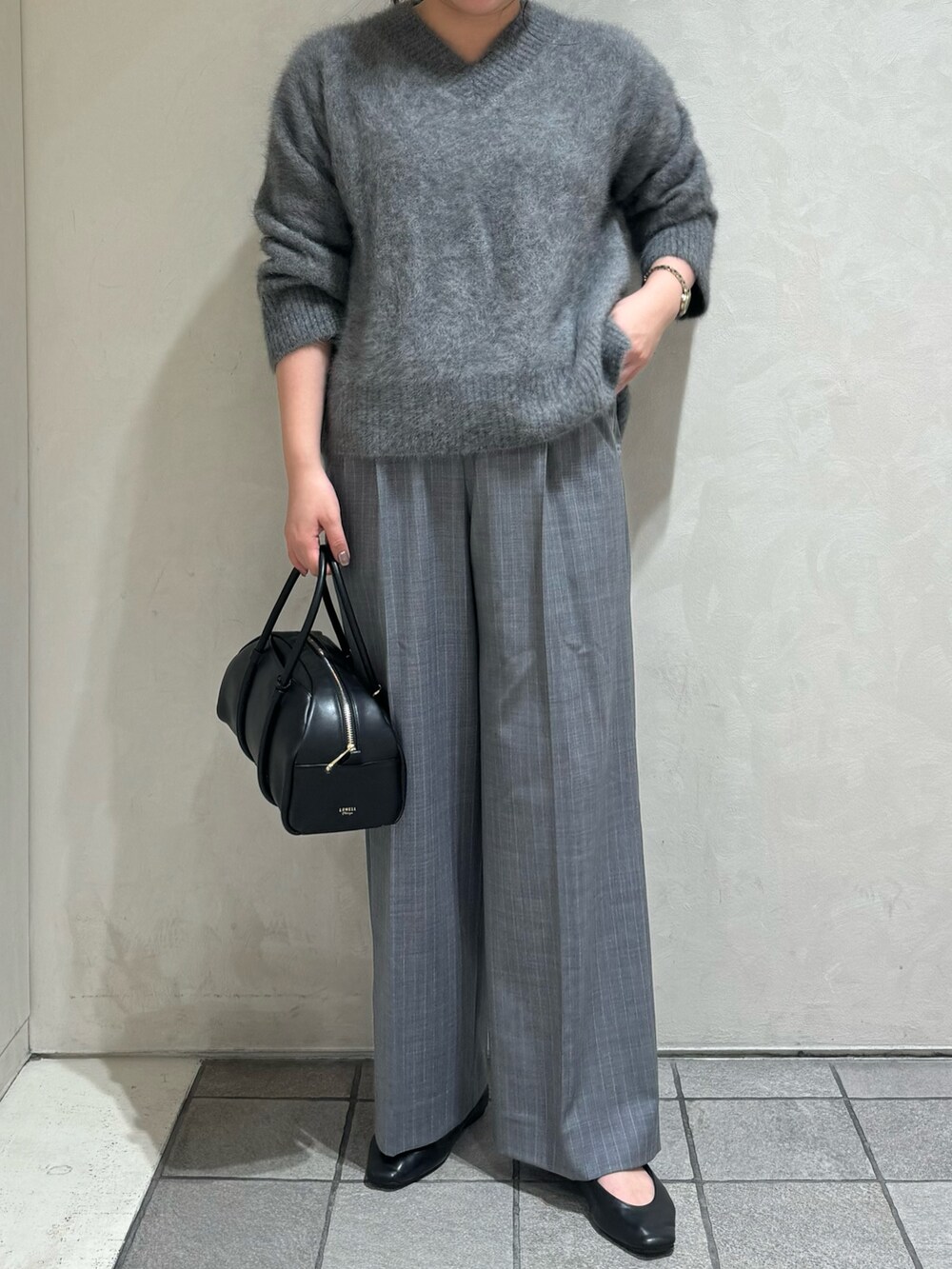 グレー系のニット/セーター、その他のスラックス、ブラック系のボストンバッグを着用したレディースの秋コーディネートの3枚目の写真