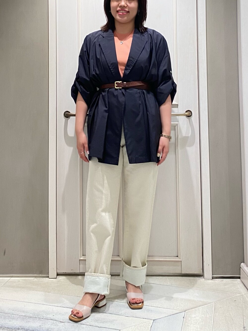 ホワイト系のデニムパンツ、ホワイト系のサンダル、ブルー系のテーラードジャケットを着用したレディースの夏コーディネートの3枚目の写真