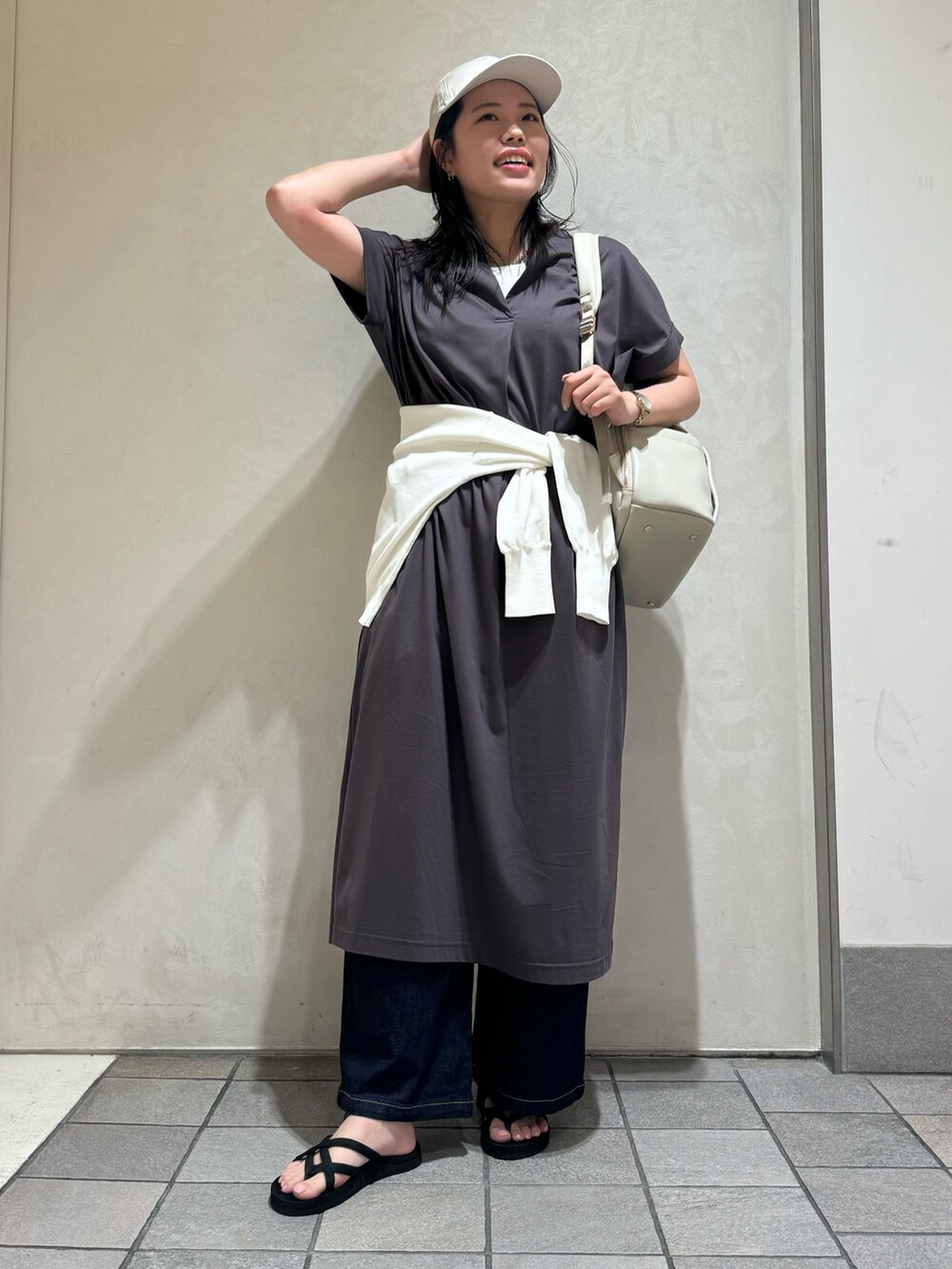 グレー系のワンピース、ブラック系のバックパック/リュック、ホワイト系のカーディガン/ボレロを着用したレディースの夏コーディネートの4枚目の写真