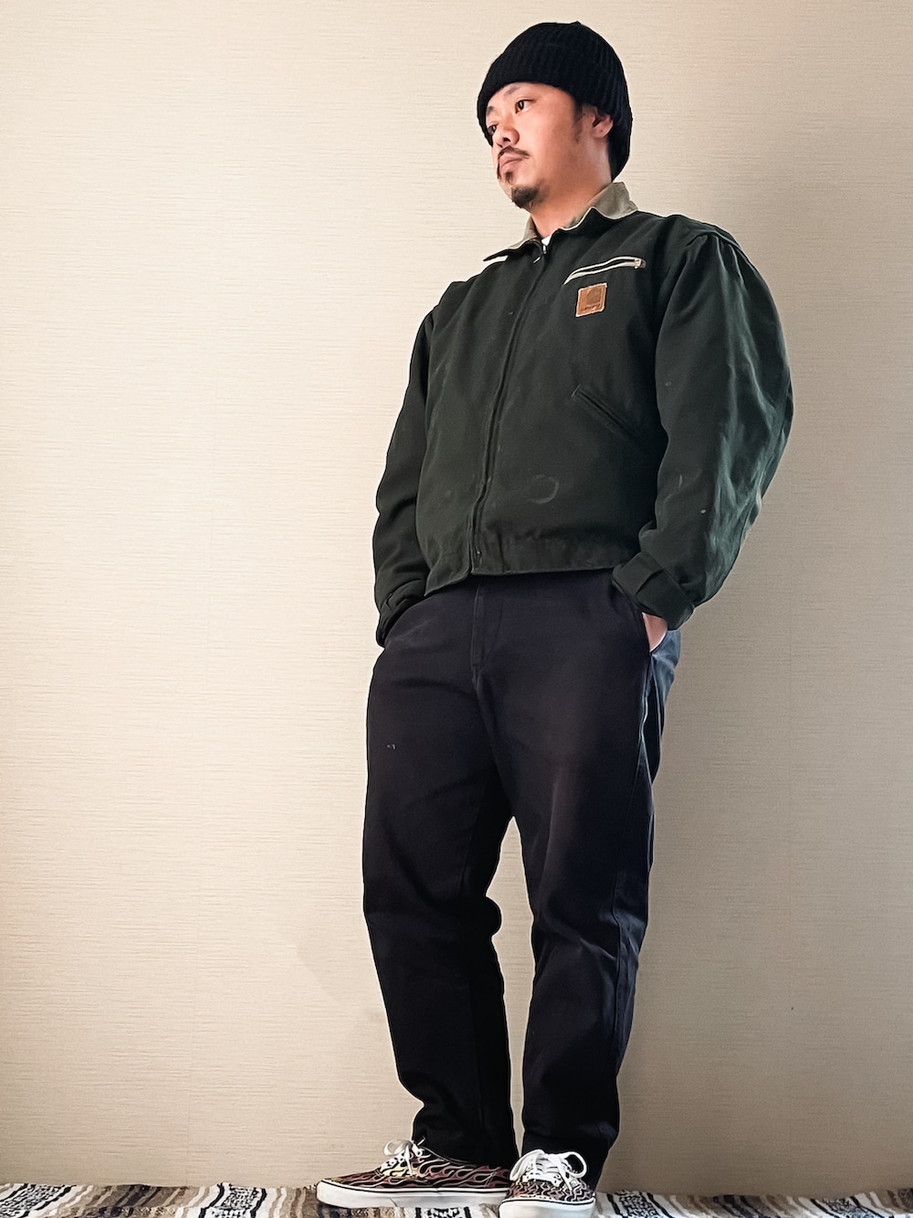 ブラック系のチノパンツ、グリーン系のブルゾン、ブラック系のスニーカーを着用したメンズの春コーディネートの2枚目の写真