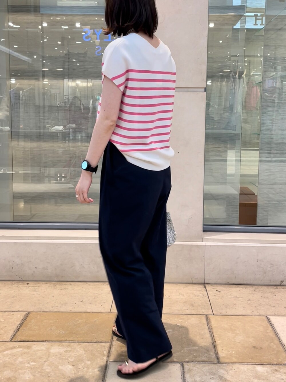 ピンク系のニット/セーター、ブルー系のその他パンツ、シルバー系のかごバッグを着用したレディースの春コーディネートの2枚目の写真