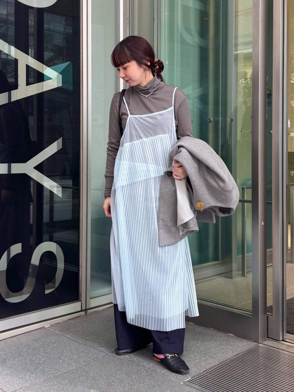 グレー系のノーカラーコート、グレー系のTシャツ/カットソー、ブルー系のワンピースを着用したレディースの冬コーディネートの4枚目の写真