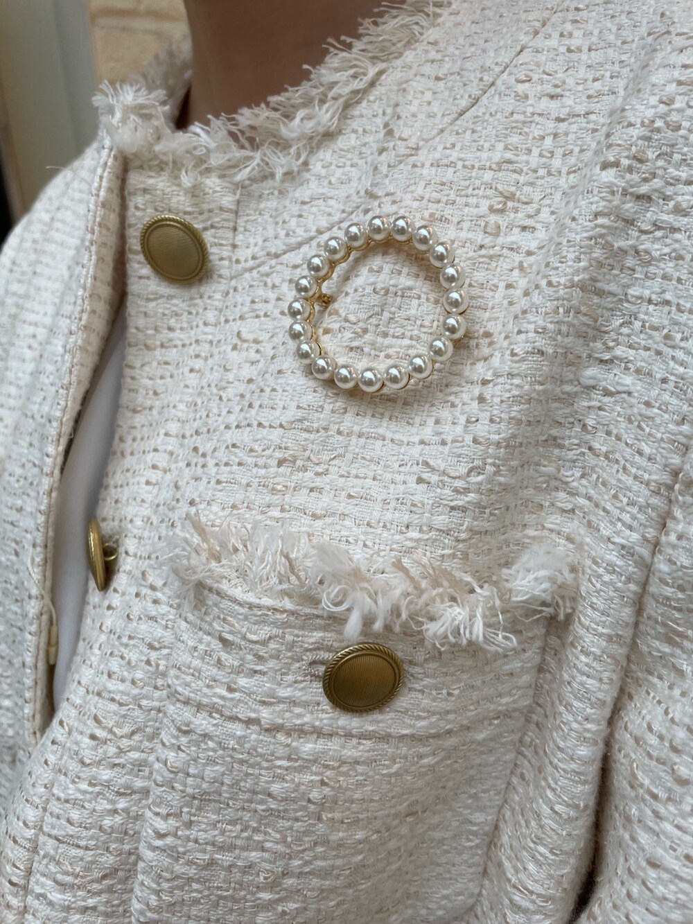 ホワイト系のノーカラージャケット、イエロー系のスカート、ブルー系のサンダルを着用したレディースの冬コーディネートの5枚目の写真