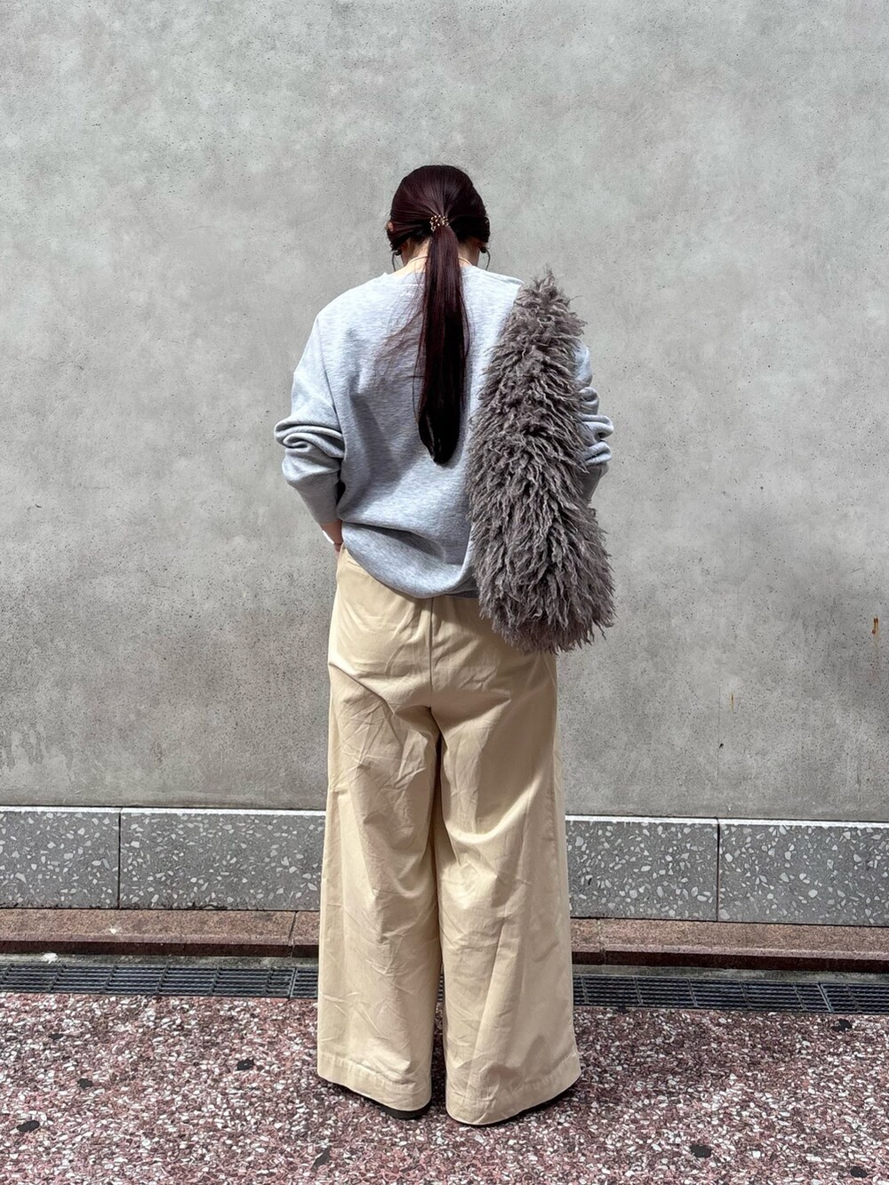 グレー系のニット/セーター、ホワイト系のその他パンツ、ベージュ系のショルダーバッグを着用したレディースの秋コーディネートの5枚目の写真