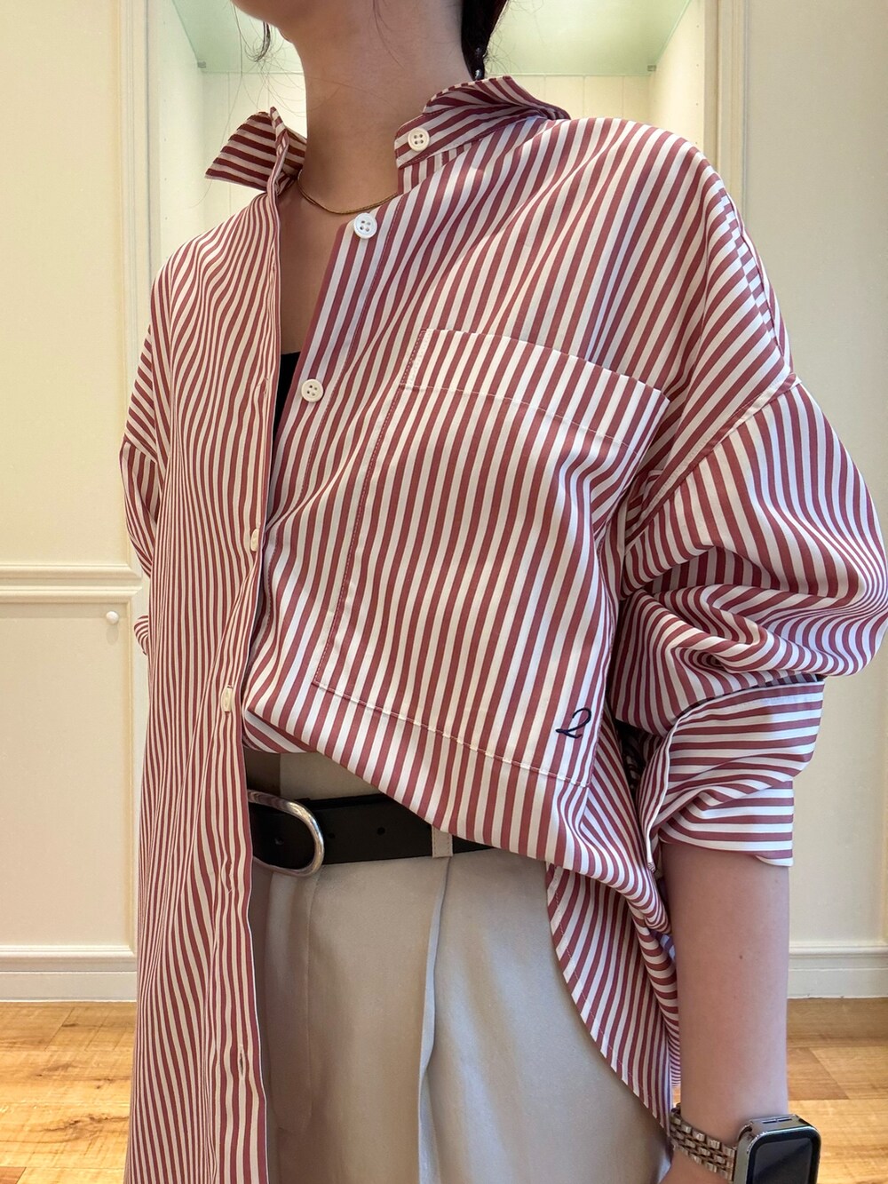 レッド系のシャツ/ブラウス、ベージュ系のその他パンツ、ブラック系のベルトを着用したレディースの秋コーディネートの2枚目の写真