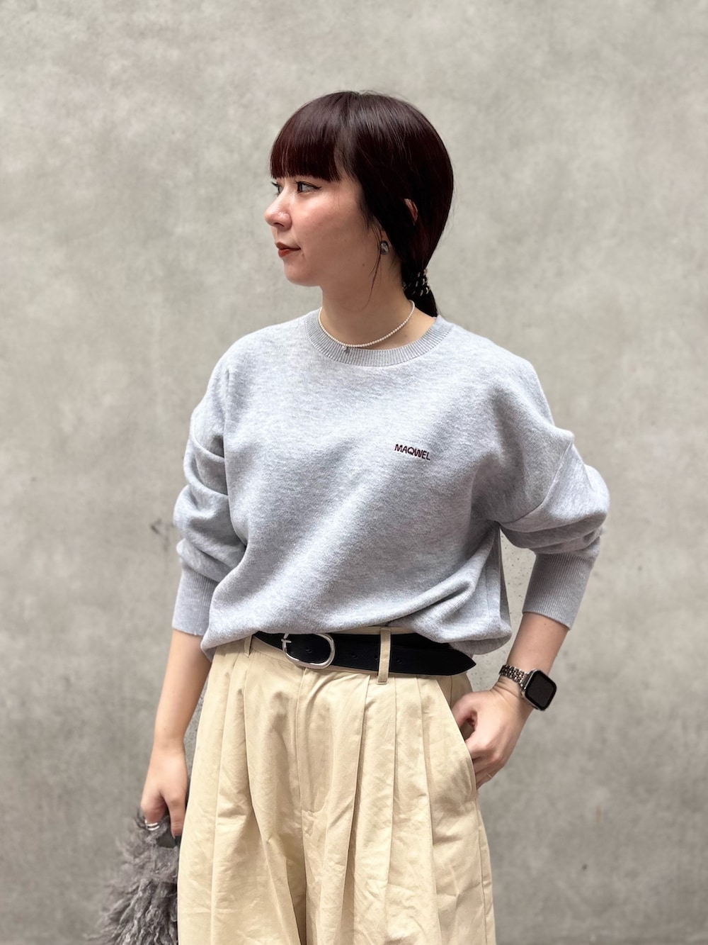 グレー系のニット/セーター、ホワイト系のその他パンツ、ベージュ系のショルダーバッグを着用したレディースの秋コーディネートの2枚目の写真