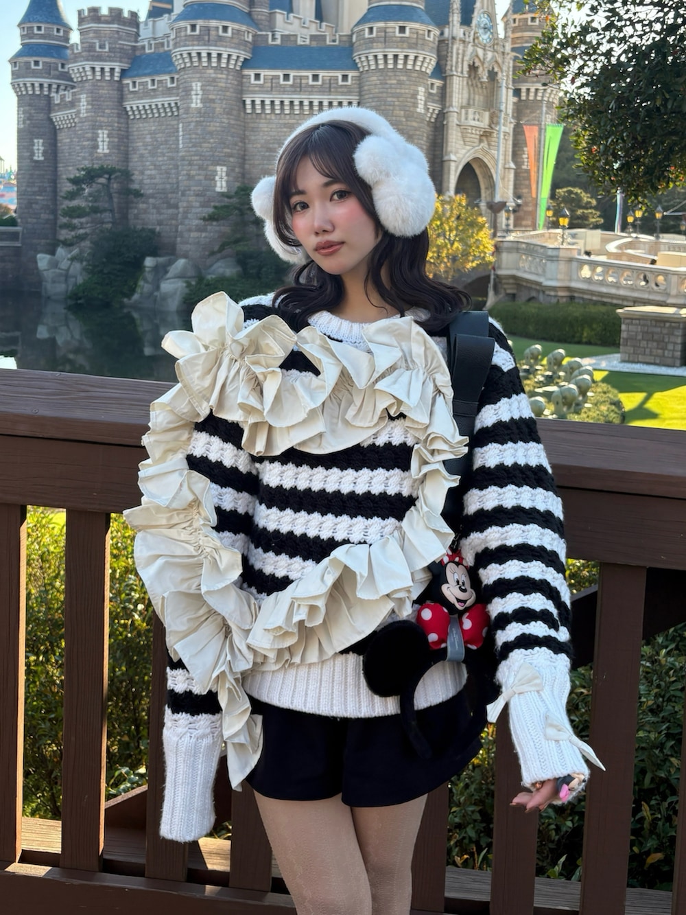 ブラック系のブーツ、ブラック系のショルダーバッグ、ホワイト系のニット/セーターを着用したレディースの冬コーディネートの2枚目の写真